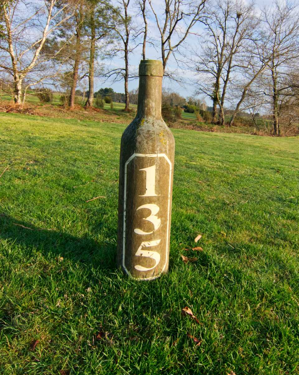 Avståndsmarkeringar i form av vinflaskor i trä talar sitt tydliga språk.